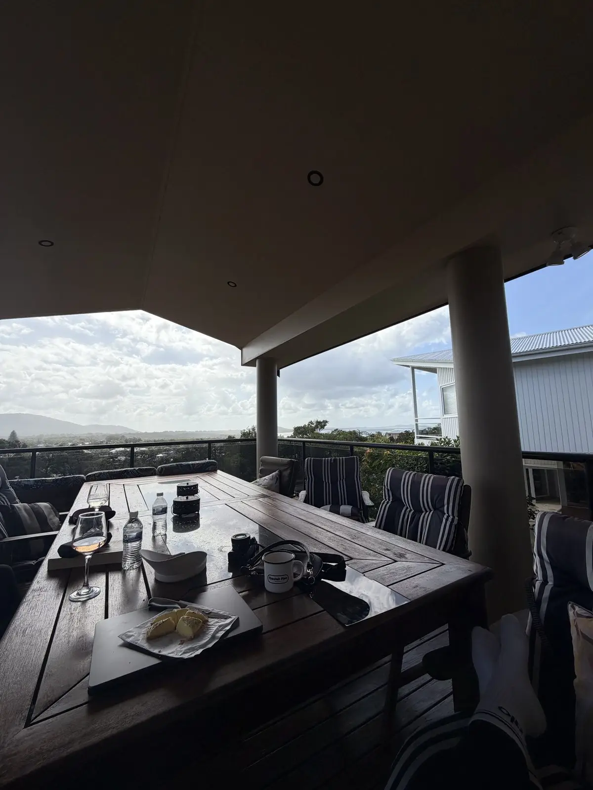 A glass of wine and something to nibble on the long deck table, the hills beyond