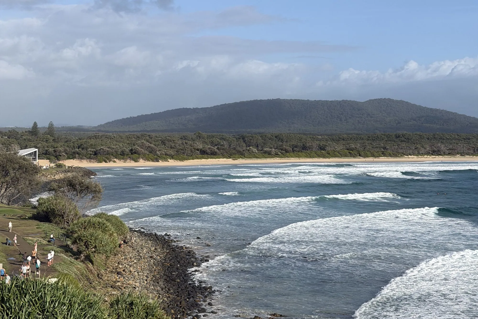 Surf breaking along the rocks below the headland at Crescent Head, the hills beyond