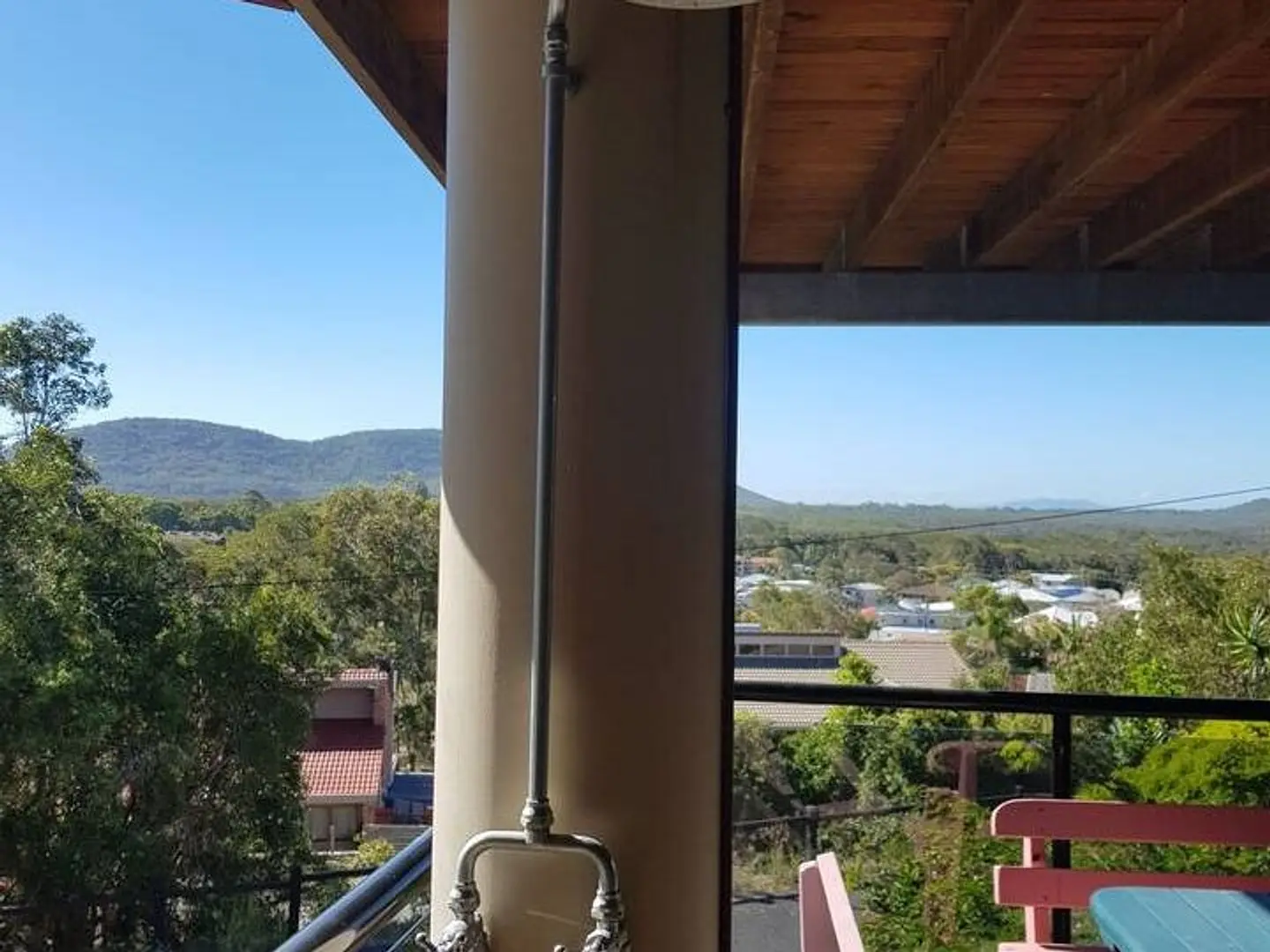The outdoor shower on the deck at The Deck, with the treetops and hills beyond