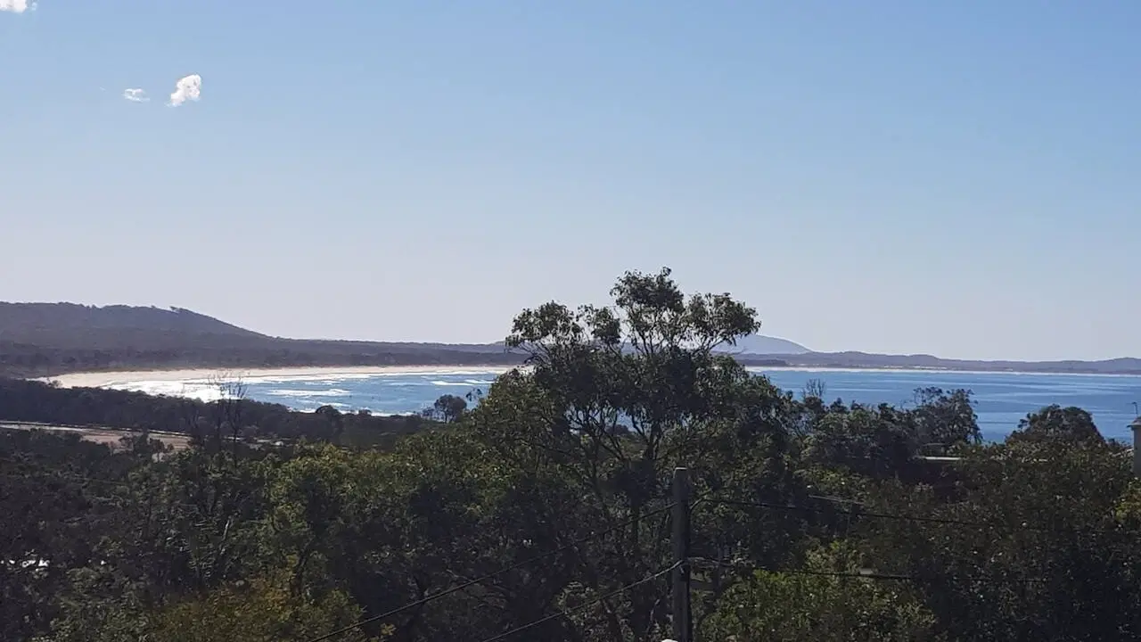 The long beach and bay north of Crescent Head, seen over the treetops