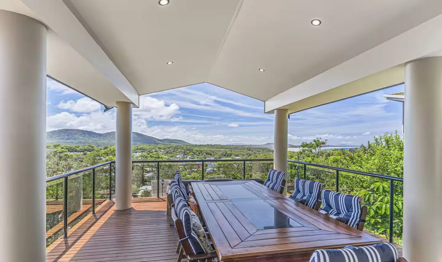 The deck at The Deck, Crescent Head — dining table for ten, columns, and the hinterland view